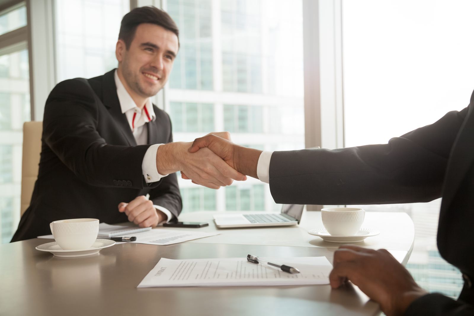 Dos personas estrechando la mano tras firmar un acuerdo