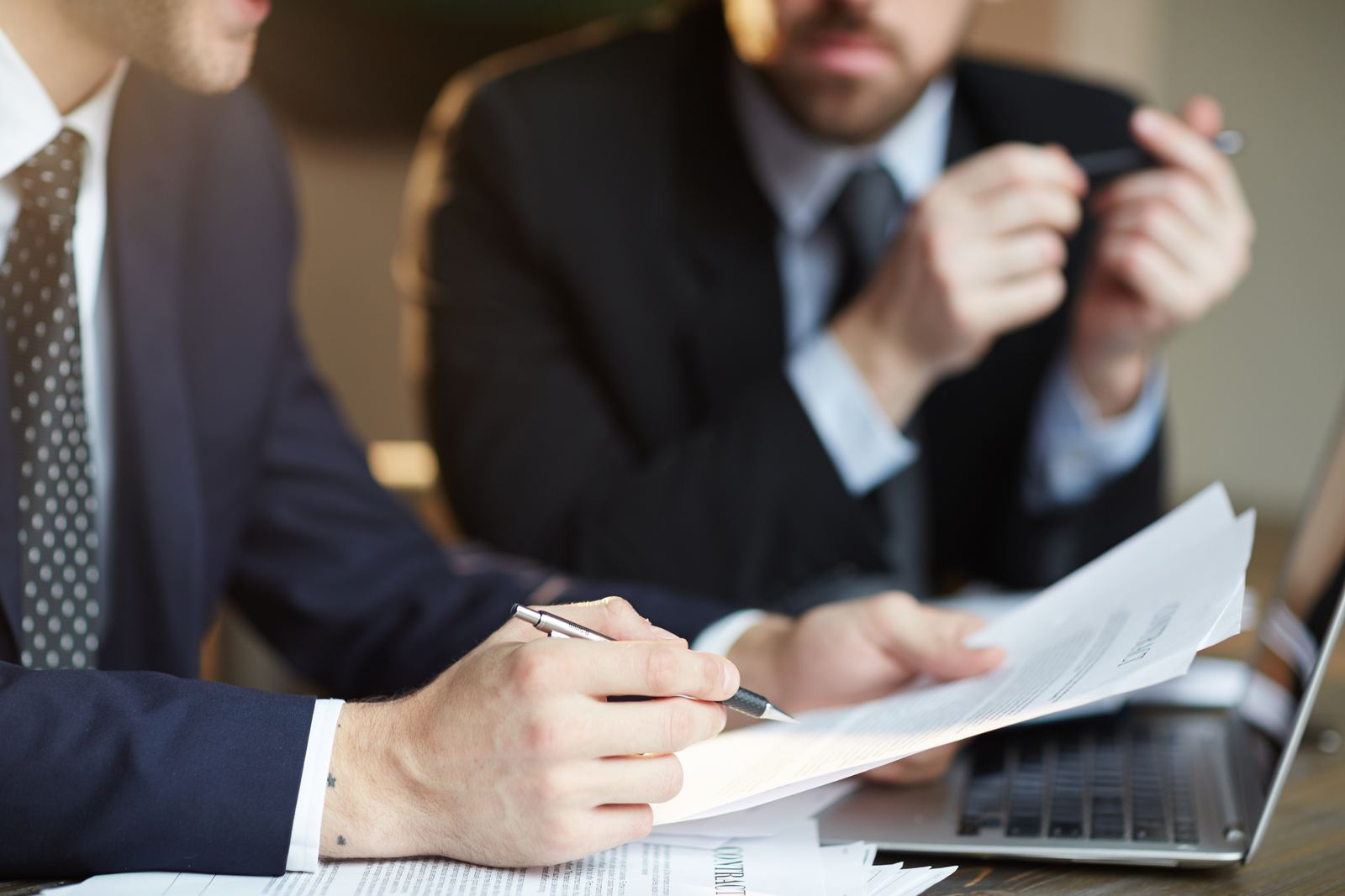 Profesionales revisando documentos de un contrato